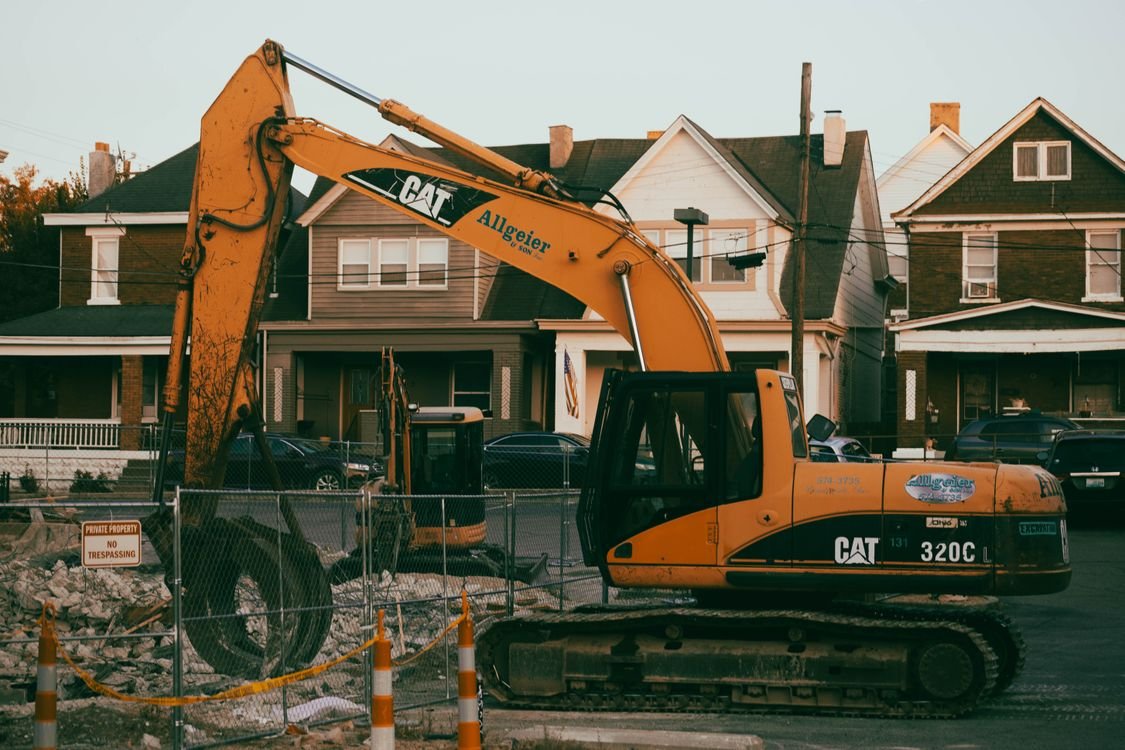 Excavator working a residential demolition site in a Tulsa-area neighborhood