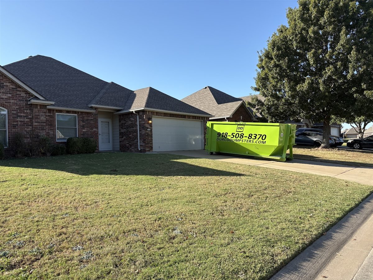 Durco Dumpsters lime green roll-off dumpster delivered to a brick home in a Tulsa-area neighborhood