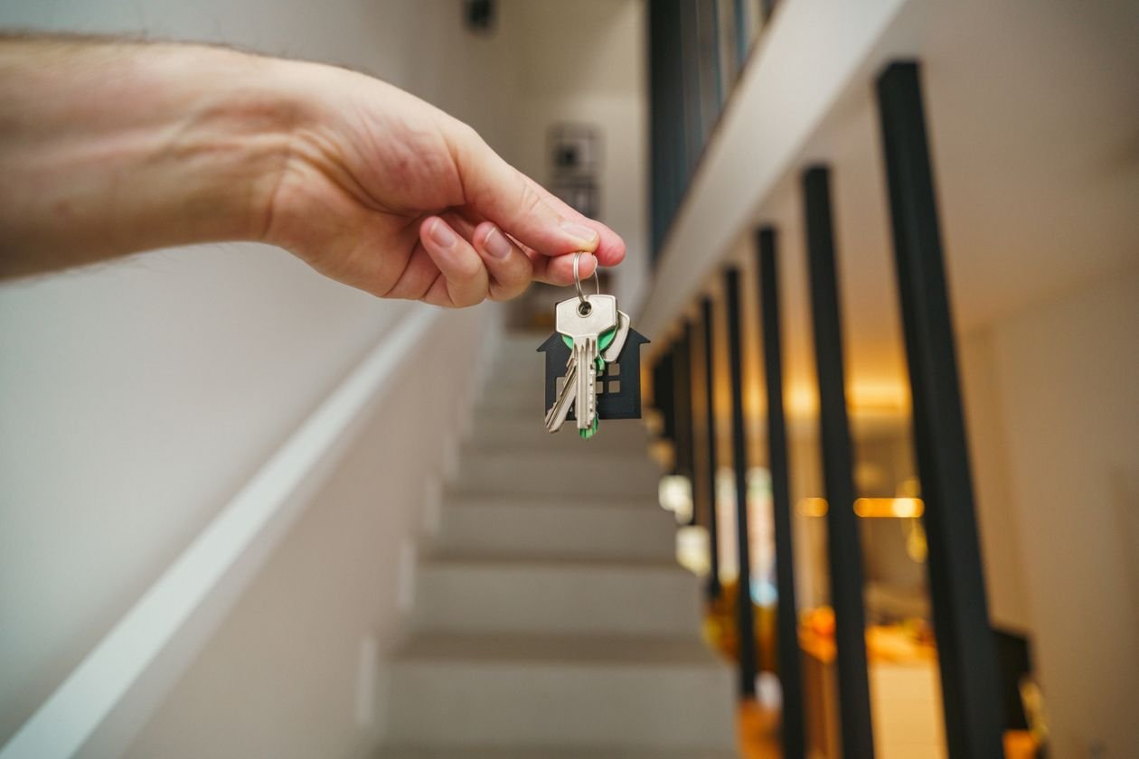 Landlord holding house keys inside a rental property after a tenant moves out