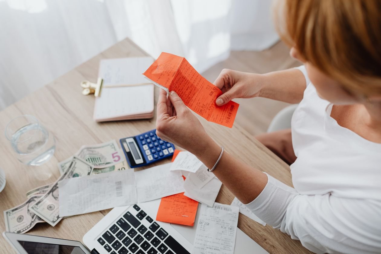 Homeowner at a desk comparing receipts and quotes with a calculator
