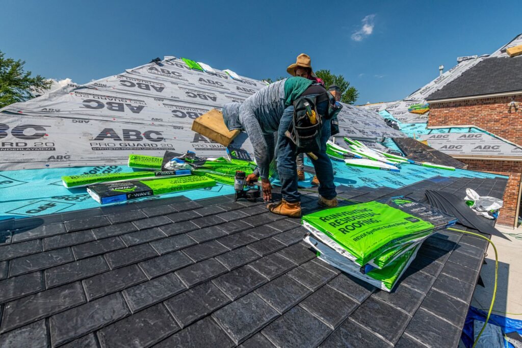 Roofing crew installing a new roof on a brick house